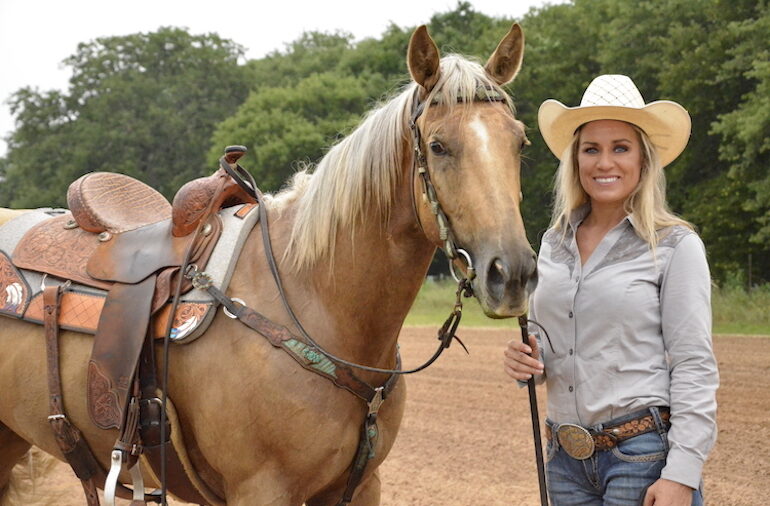 Danyelle Campbell standing with palomino horse