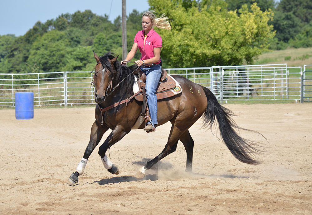 Even at a lope, it is important to keep your horse as relaxed as possible, as Janna demonstrates here. Her horse is soft, not pulling to the outside or dropping his shoulder. She’s also working on freeing up his front end and driving with his rear end.