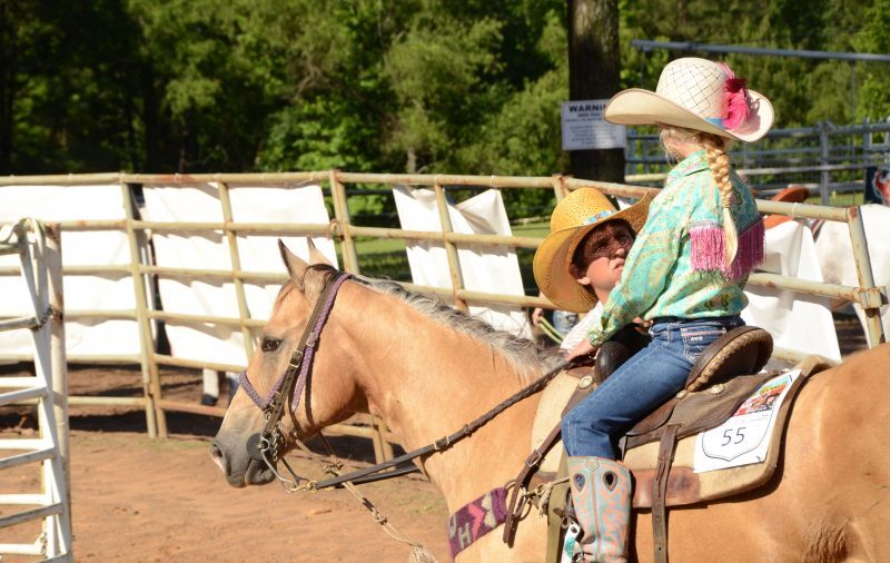 man instructing young girl on horse