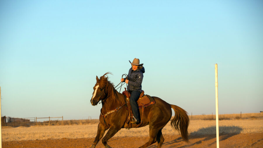 Kylie Weast trotting horse around pole