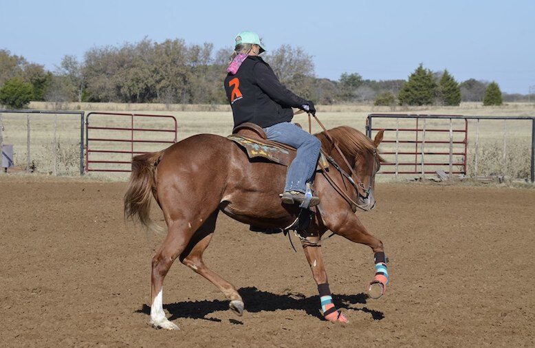 Jolene Montgomery riding a colt and working on training the barrel pattern