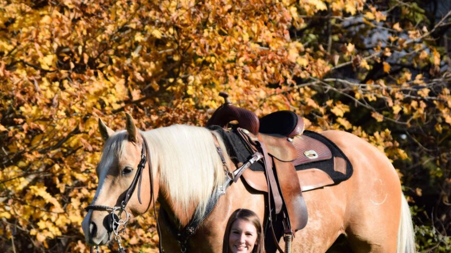 Ashley Wyss kneeling with dog and horse