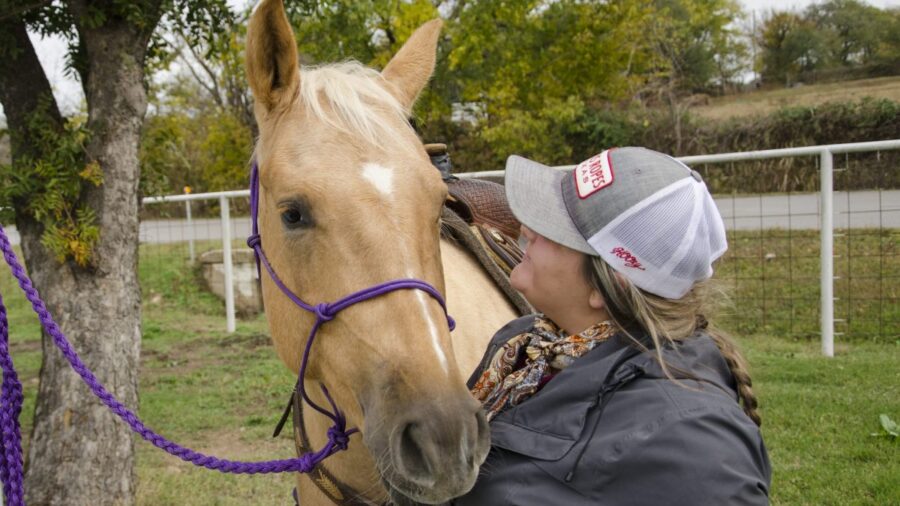 Kailey Sullins hugging horse's face