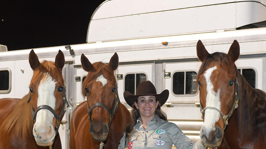 Brittany Pozzi Tonozzi standing with three mares