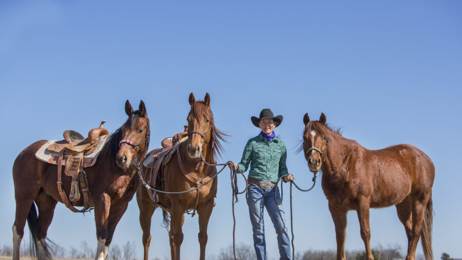 Dona Kay Rule standing with three horses