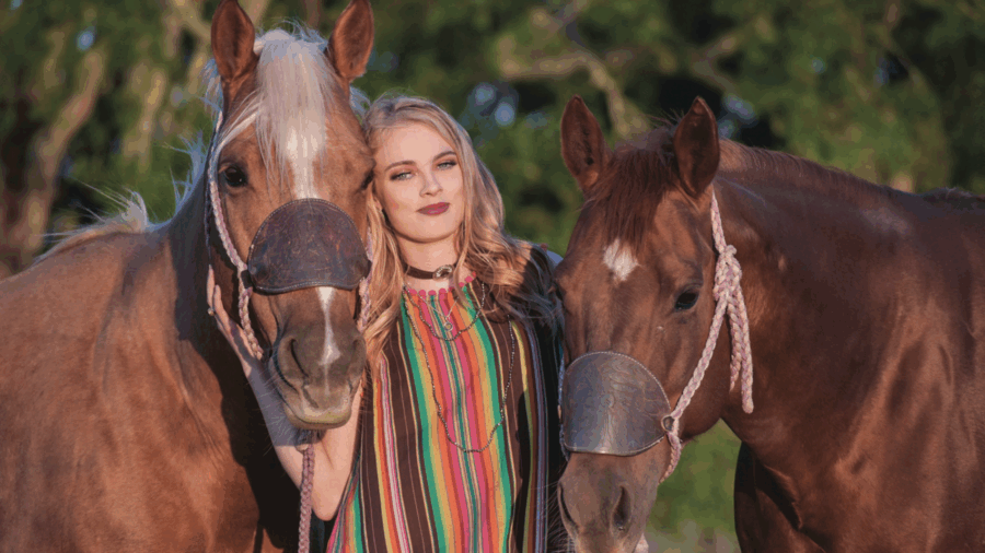 Jimmie Smith standing between two horses