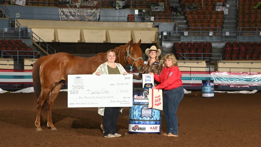 Molly Otto standing with horse Sixappeal and winners check