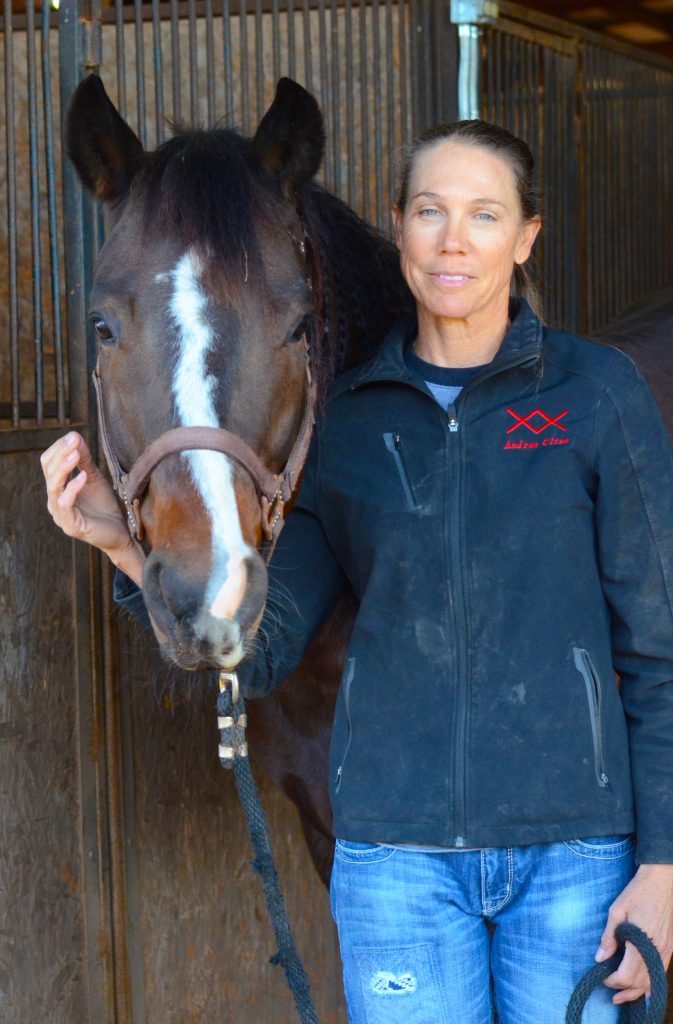 Andrea Cline standing with brown horse
