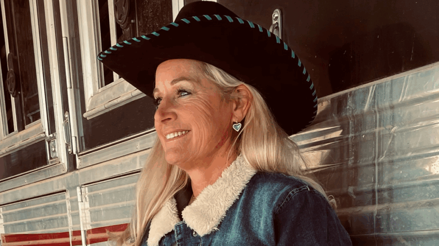 woman standing next to horse trailer