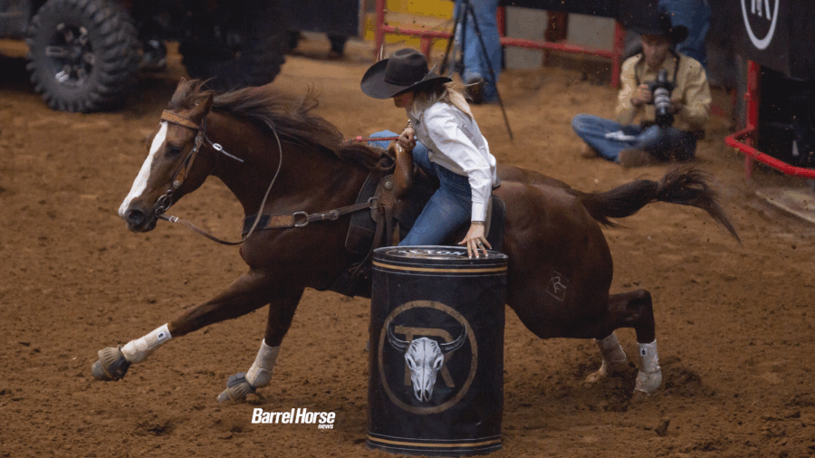 Laura Mote reaching down to set up a barrel while horse turns