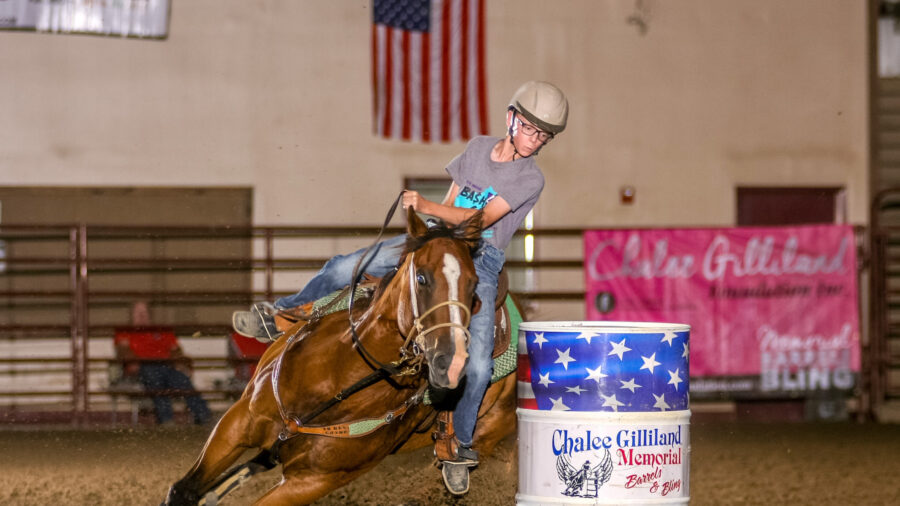 boy turns a barrel on his horse