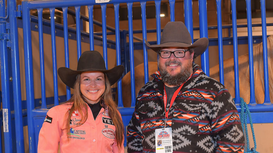 Miles McNarland and Hailey Kinsel stand in front of stall