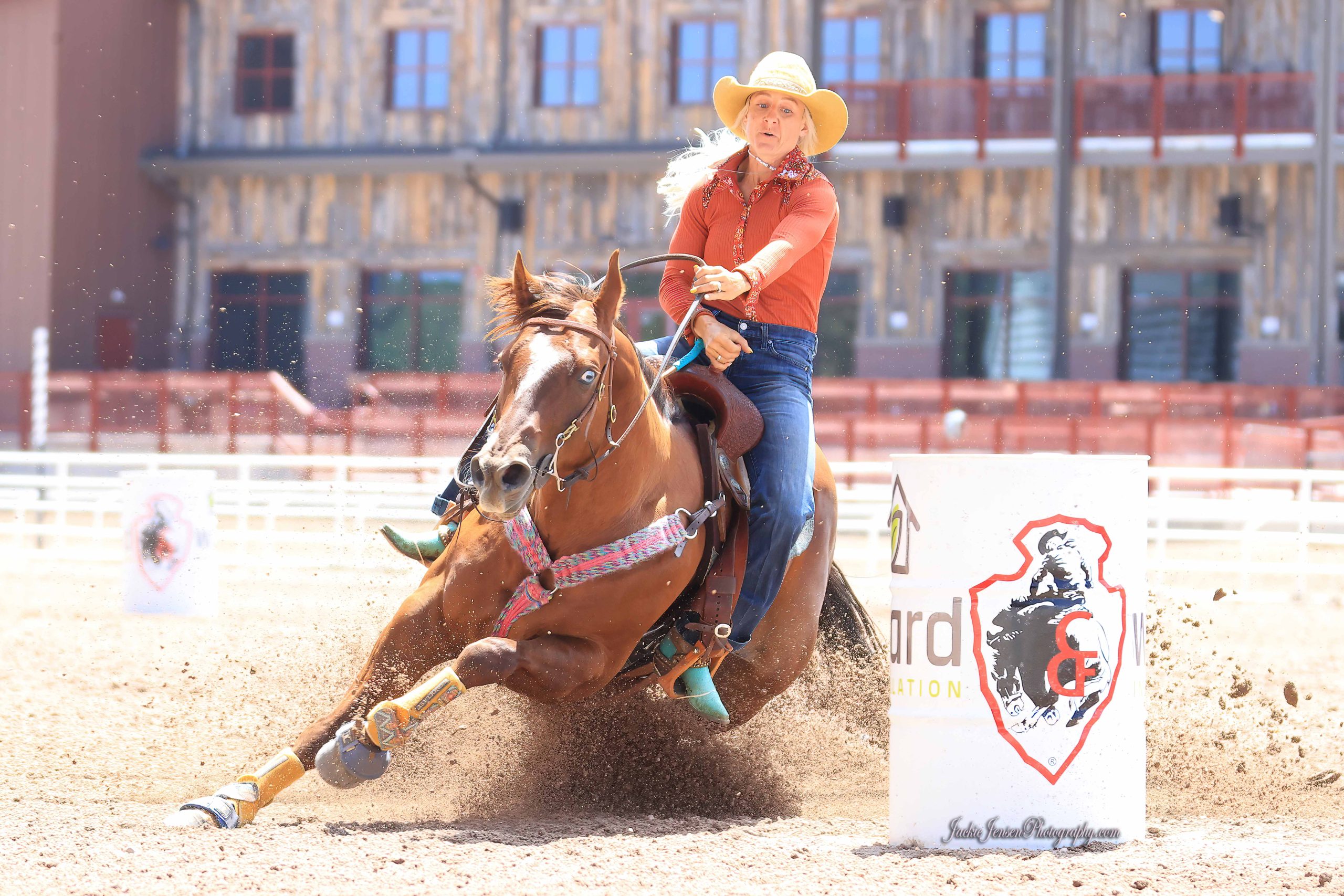 Barrel Racing A young cowgirl with long blond hair in a blue shirt rides on  the