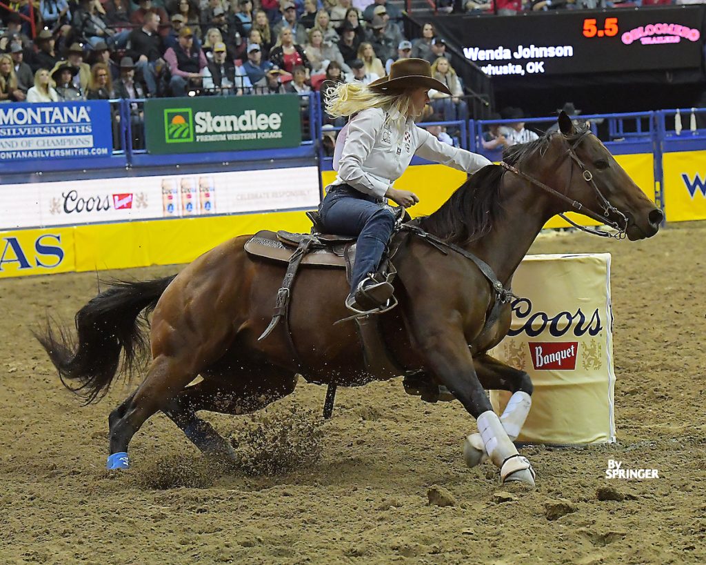 Wenda Johnson turns a barrel on bay horse