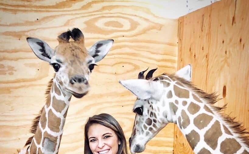 girl with two baby giraffes