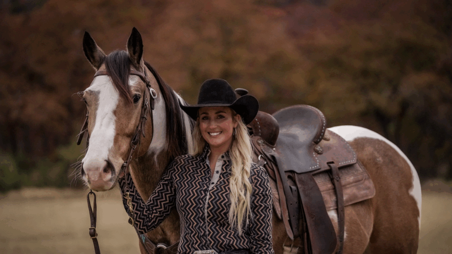 Maggie Wright standing with buckskin Paint horse